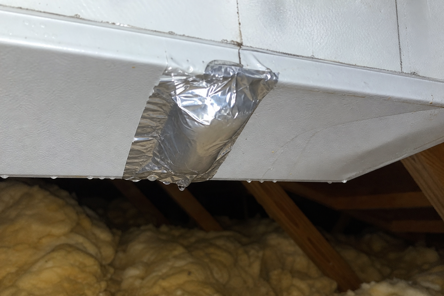 Butyl tape wrapped around HVAC ductwork in an attic